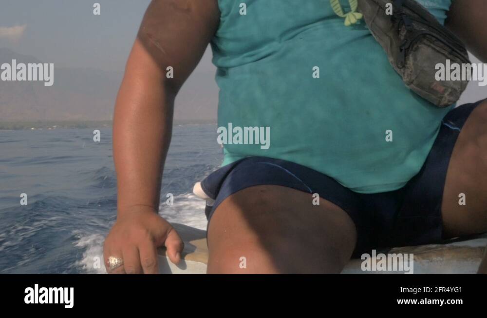 Slow mo of a happy boat captain waiving and giving the thumbs up to the ...