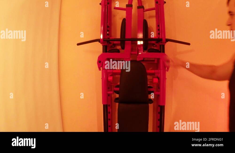 Man Holds on to a Horizontal Bar on the Wall Bars in Home Sport Hall