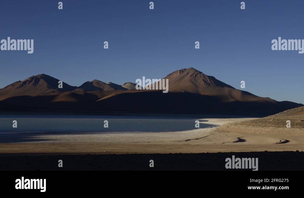 Time-lapse of night falling over volcanoes in the South American mountain range, showing the Andean volcanic arc silhouetted against a twilight sky
