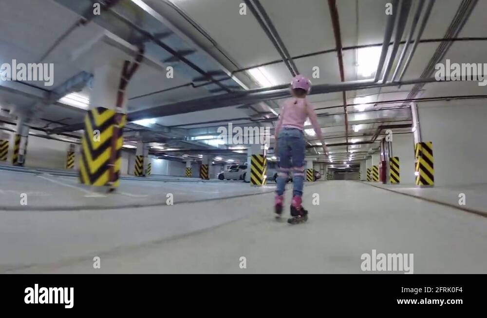 Boy and girl roller skate in underground parking, back view Stock Video