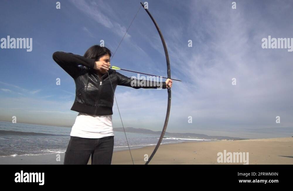 A female archer shooting targets with her bow and arrow Stock Video