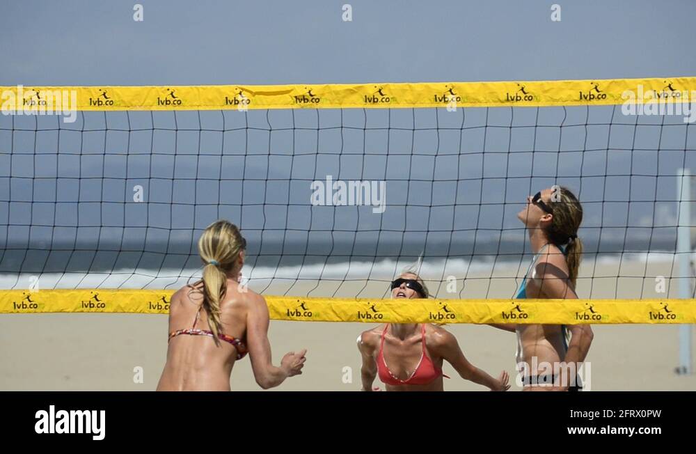 Closeup of women beach volleyball players spiking and blocking the