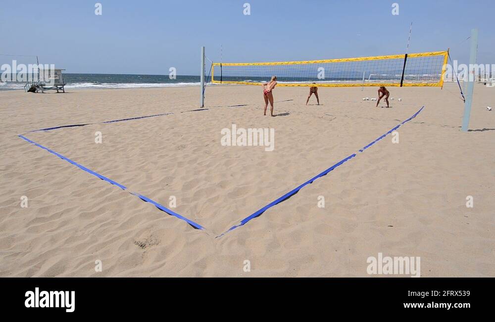 Establishing master shot of women beach volleyball players jump serving