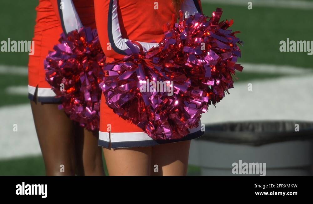 Detail of high school cheerleaders cheering with their pompoms at a