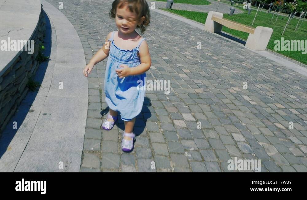 Little girl walking in the park. Little girl having fun jumping Stock ...