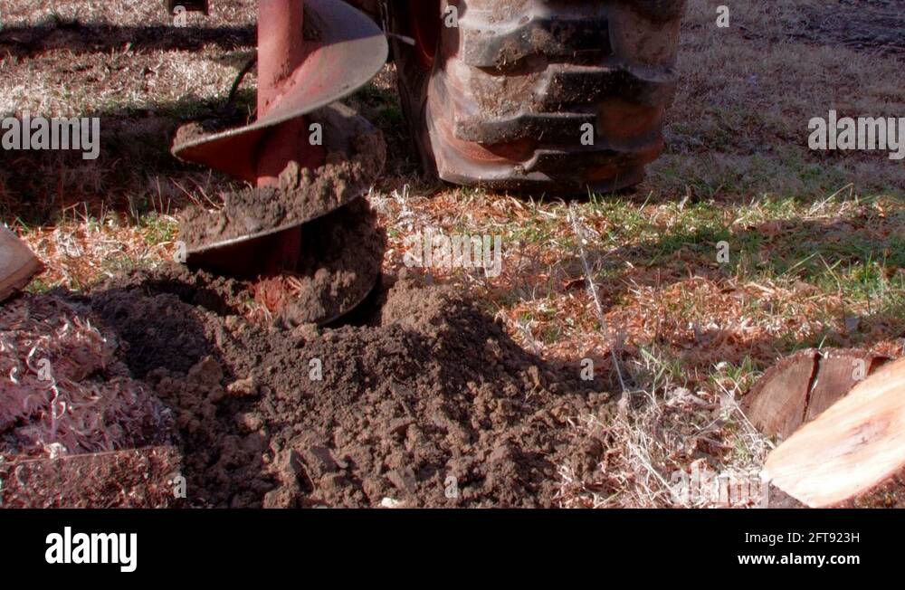 Drilling post hole with backhoe and auger Stock Video Footage Alamy