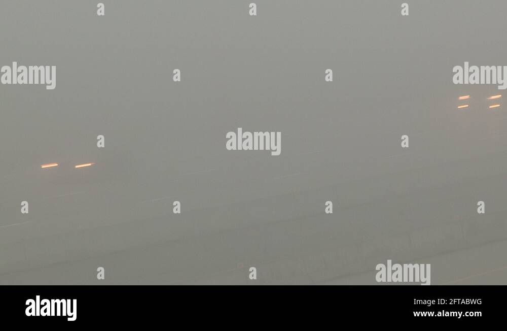 Severe fog with drivers driving in zero visibility on highway Stock