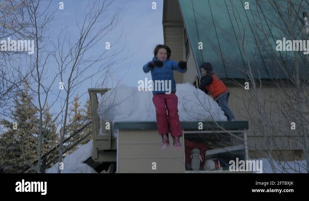 Little girl jumps off the shed roof into the snow
