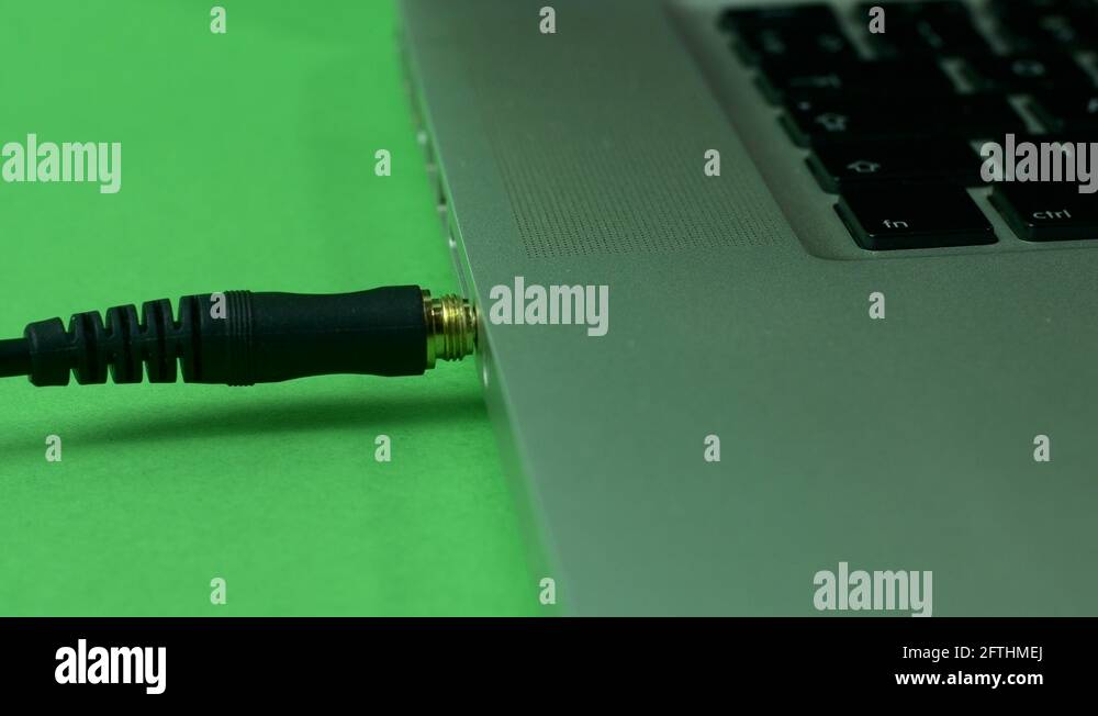 Hand Pulling Out Of Laptop Headphones Jack, Green Screen Stock Video