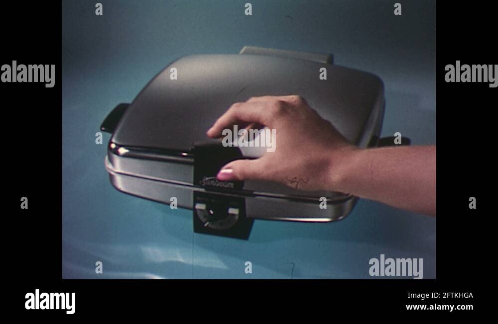 1960s Waffle iron, hand lifts lid to show waffles / Hamburgers and