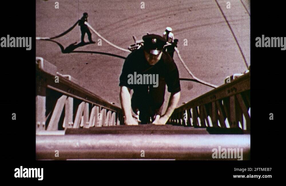 1950s : Men climb ladder/Man throws rope off side of building Stock ...