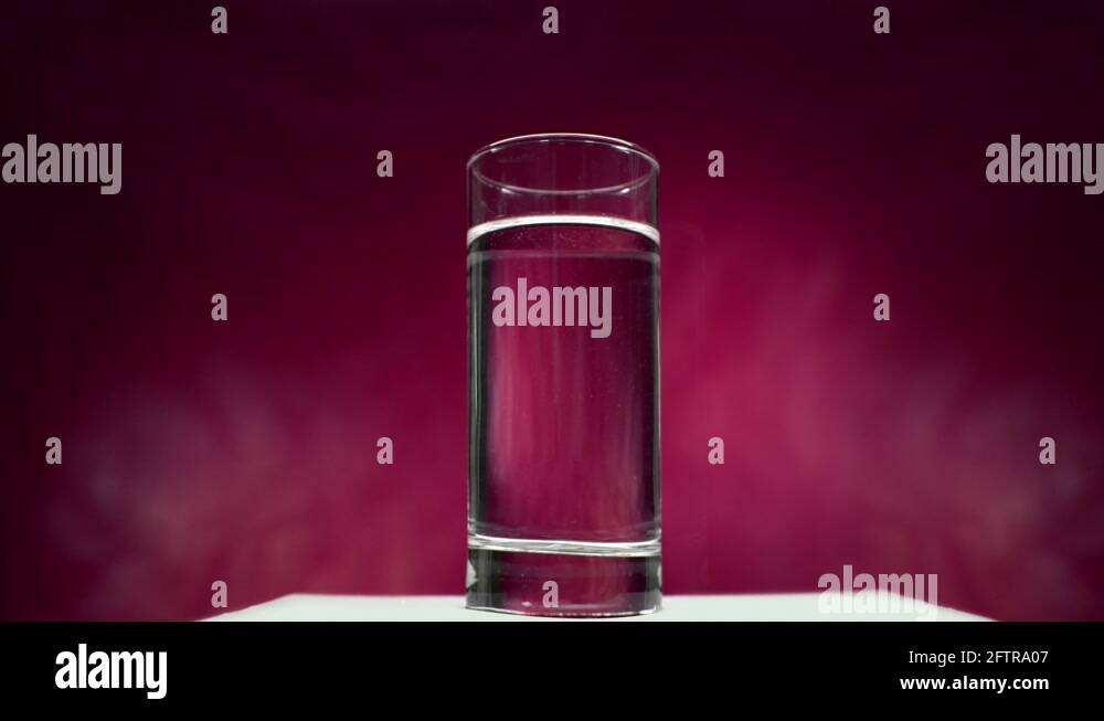 Aspirin tablet dissolves in water on a red background Stock Video