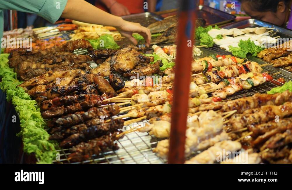 Traditional Asian meat satay street food cooking outdoor at night