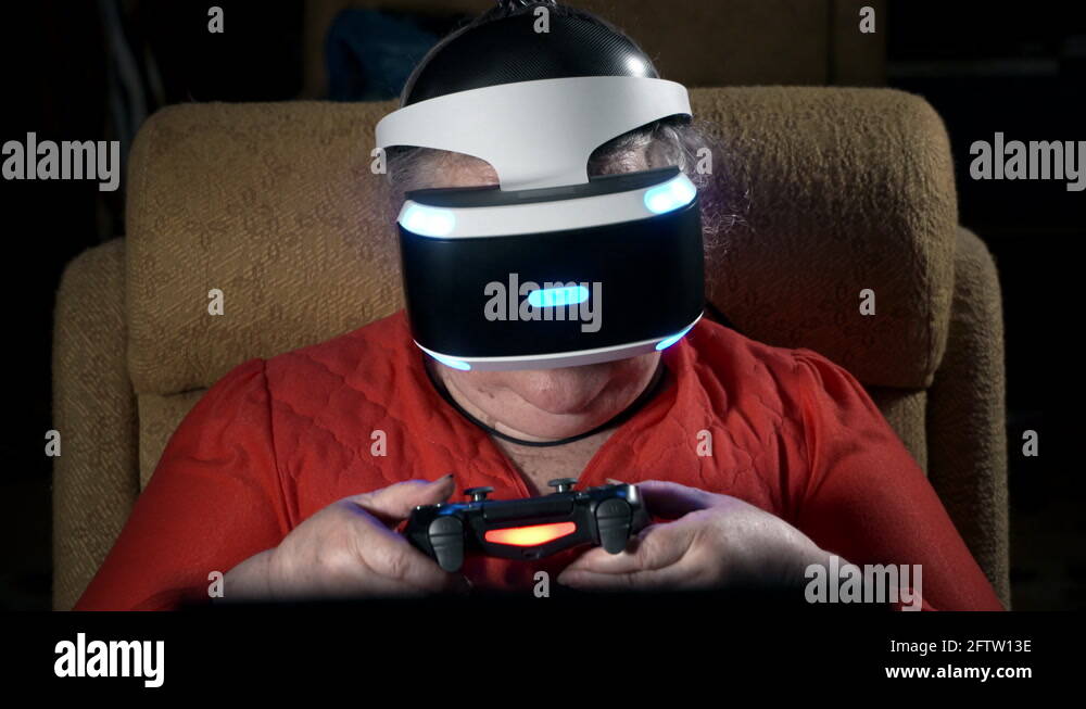 Elderly woman in front TV screen uses VR headset and wireless gaming