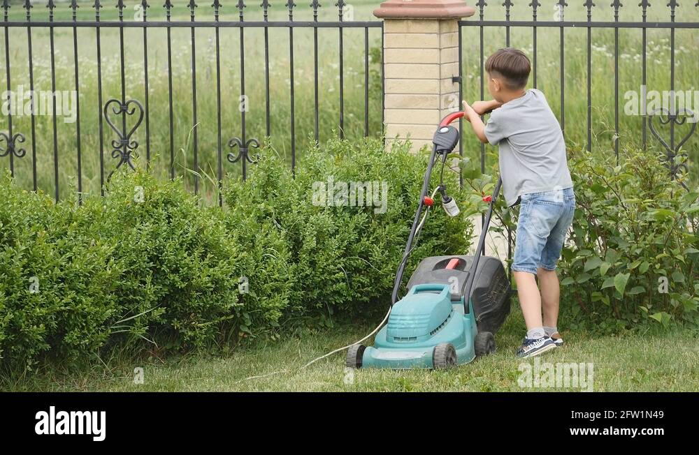 Ten year old boy mowing the lawn with a big lawn mower Stock Video Footage Alamy