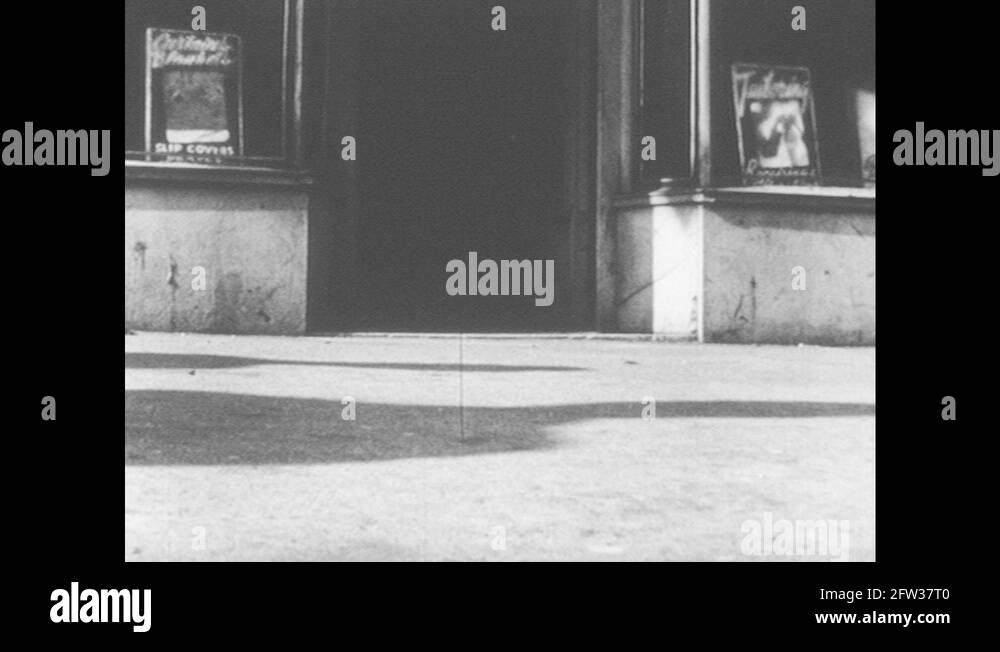1950s Feet walk past doorway, taps cane. Storefronts. Man walks down