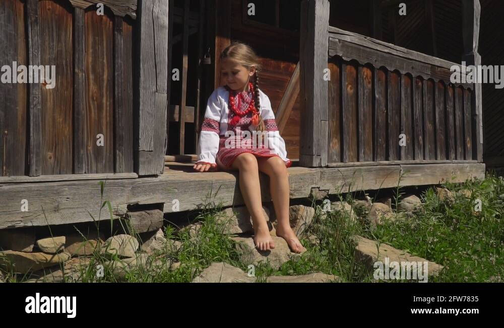 little girl is sitting on the porch of the house Stock Video Footage ...