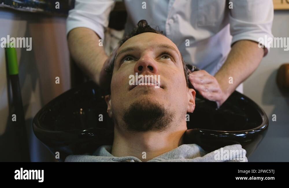 Hairdresser man washing hair with shampoo in the Stock Video