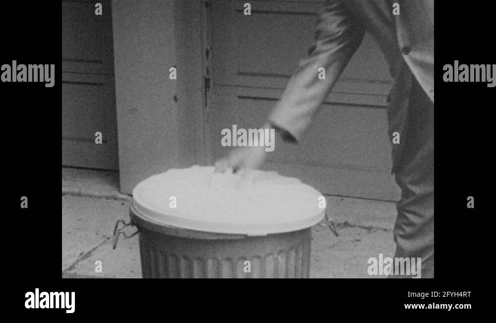 1960s Men remove trash can lid. Men rifle through trash. Men throw trash from Stock Video