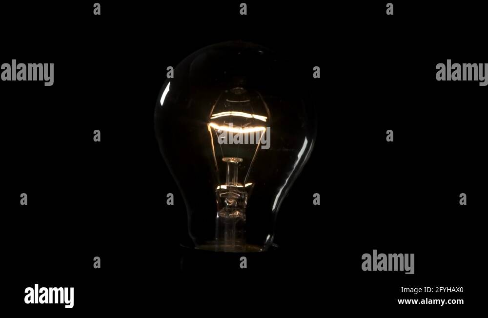 Light bulb flickering and turning on. 4k Black background Stock Video