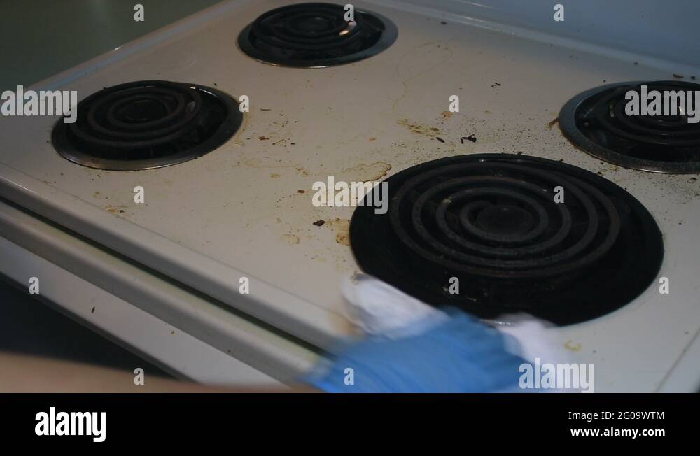 washing grease stains off of a stove top Stock Video Footage Alamy
