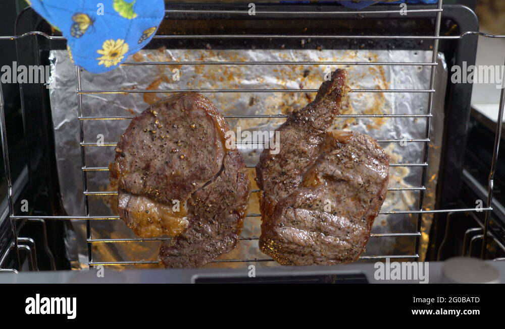 Cooking grilled steak ribeye in the oven with broiler top view Stock
