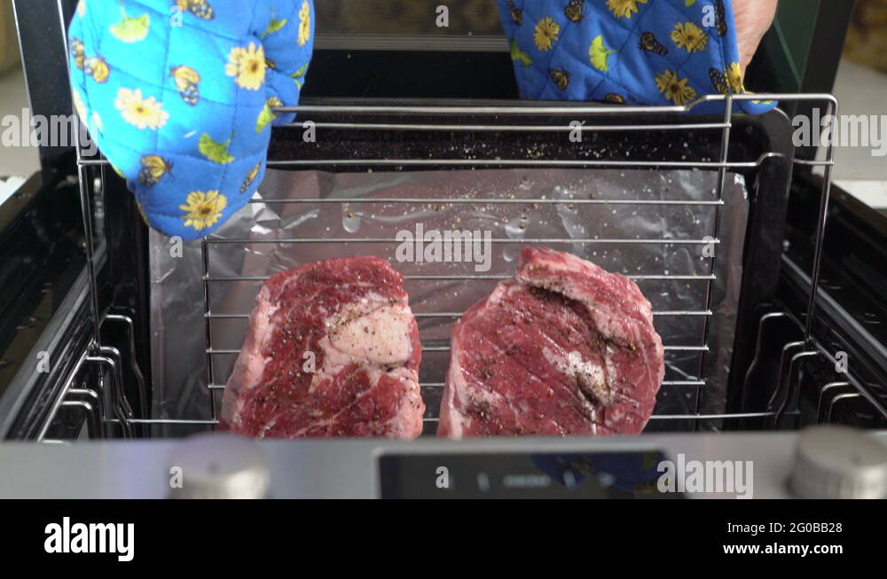 Cooking grilled steak ribeye in the oven with broiler top view Stock