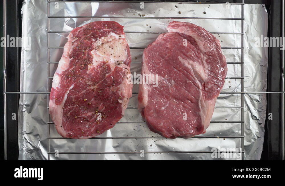 Cooking grilled steak ribeye in the oven with broiler top view Stock