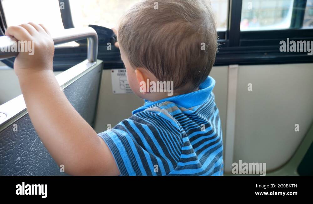 A cute little boy riding the public city bus with his family Stock ...