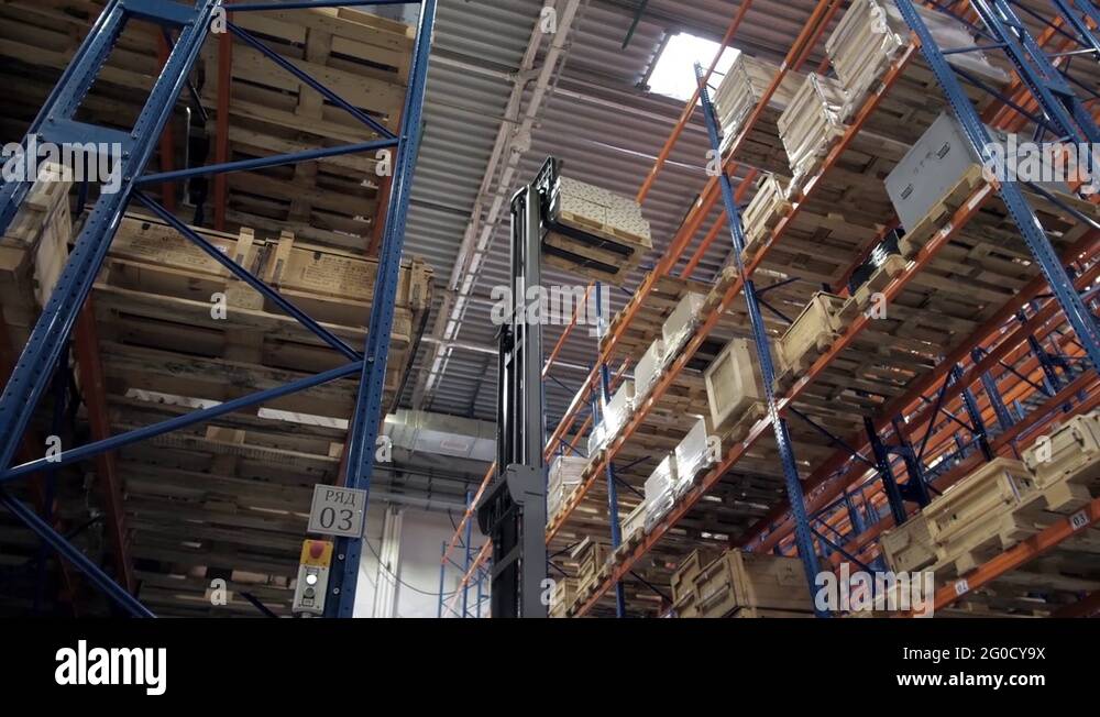 warehouse worker driver in uniform loading cardboard boxes by forklift ...