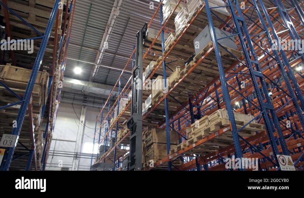 warehouse worker driver in uniform loading cardboard boxes by forklift ...