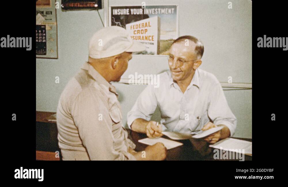 1950s Man in hat talks to man behind counter. Text "Quonset Grain
