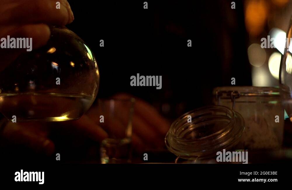 Male hands pouring alcoholic beverage vodka from decanter in glass