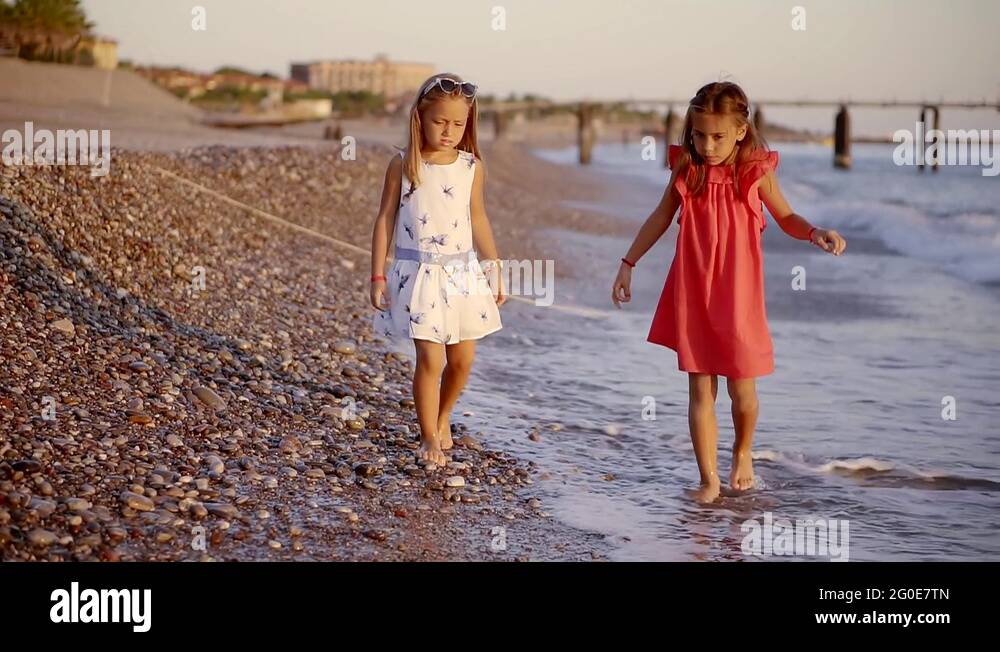 Two little girls are walking together on the beach Stock Video Footage ...