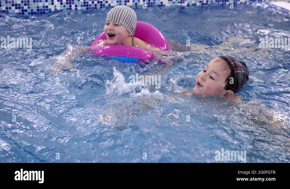 Children's water games in the pool. Little kids bathe in the swimming