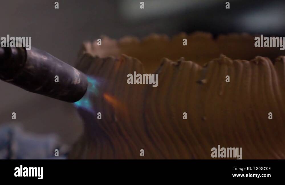 Potter burns the pot with a gas burner. Slow motion. Closeup Stock