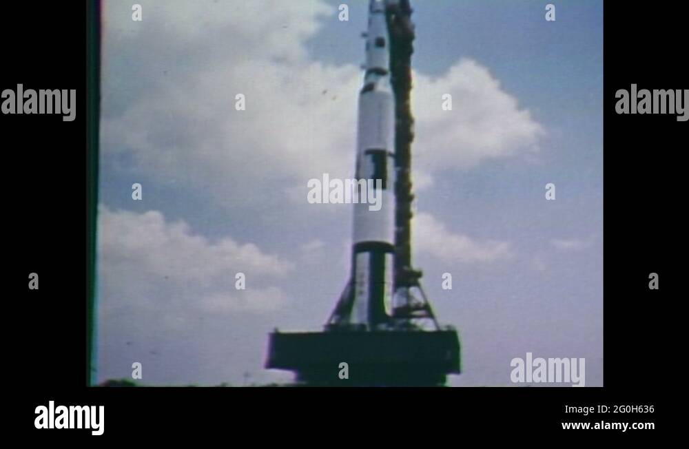 1960s Saturn V rocket on moving launch platform. Helicopter ascends