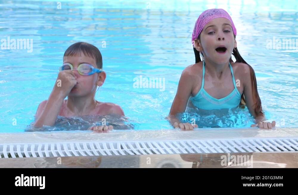 Brother and sister in the pool dive under the water in turn Stock Video ...