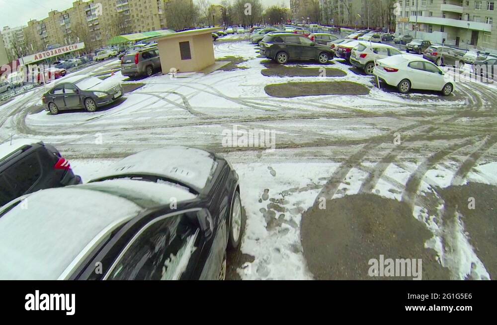 Cars stands on parking covered by snow near spare parts shop Stock