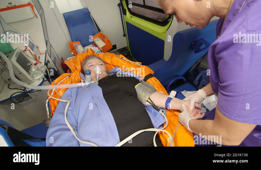 EMT paramedic preparing an intravenous infusion to patient in ambulance