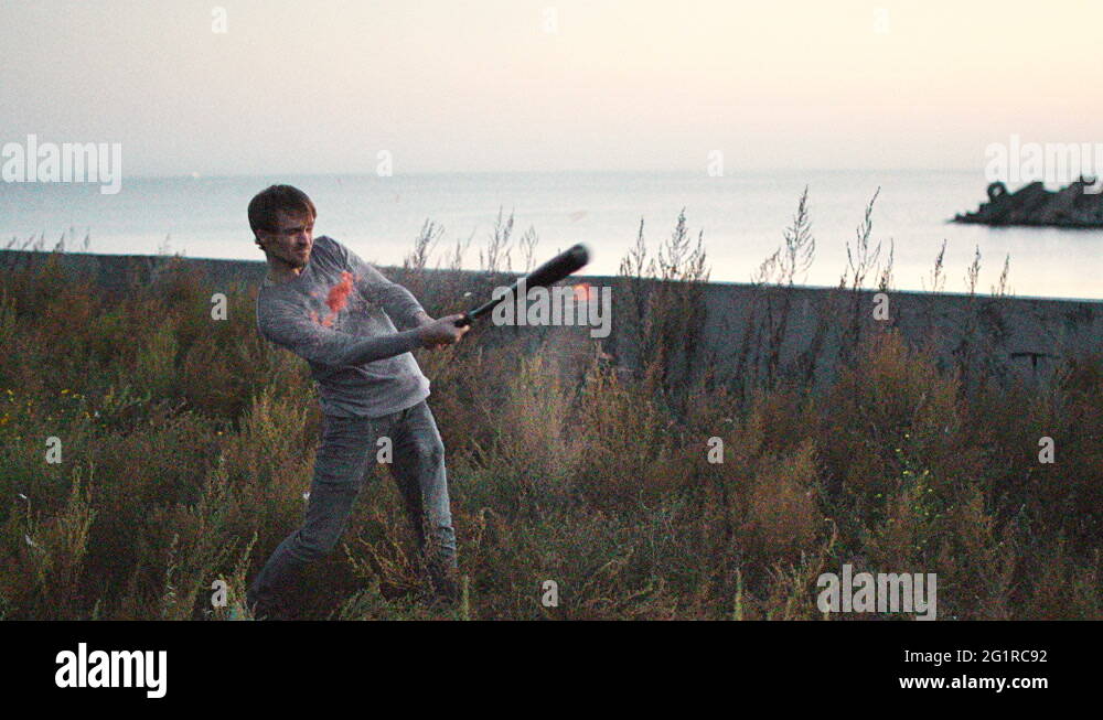 Guy hit a fruit bat slow motion. Man break vegetable piece. Baseball