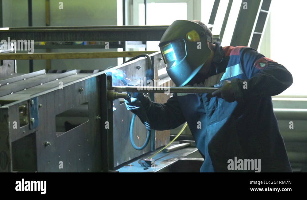 Man welder welds the parts of the structure in slow motion Stock Video