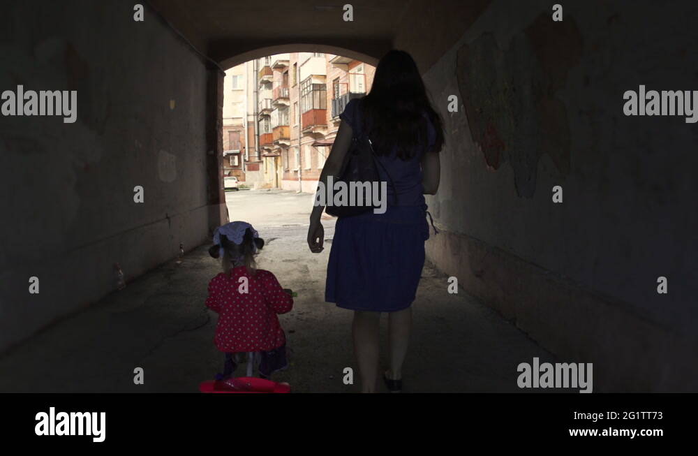 Mother goes through the arch with her daughter on a tricycle, slow ...