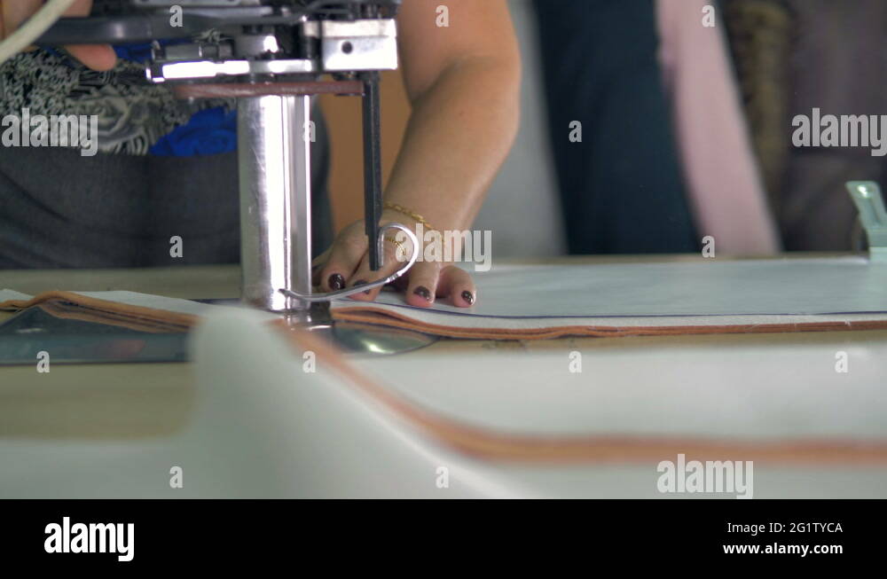 An industrial fabric cutter in use under spotlight Stock Video Footage