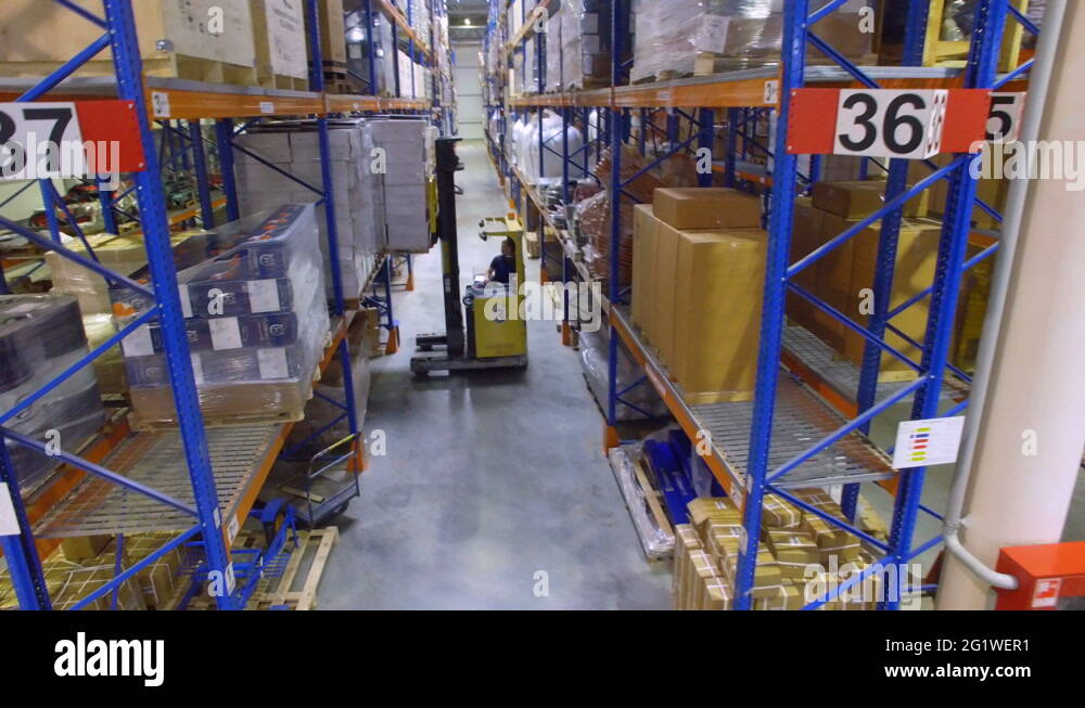 Forklift inside huge industrial warehouse. Aerial shot Stock Video