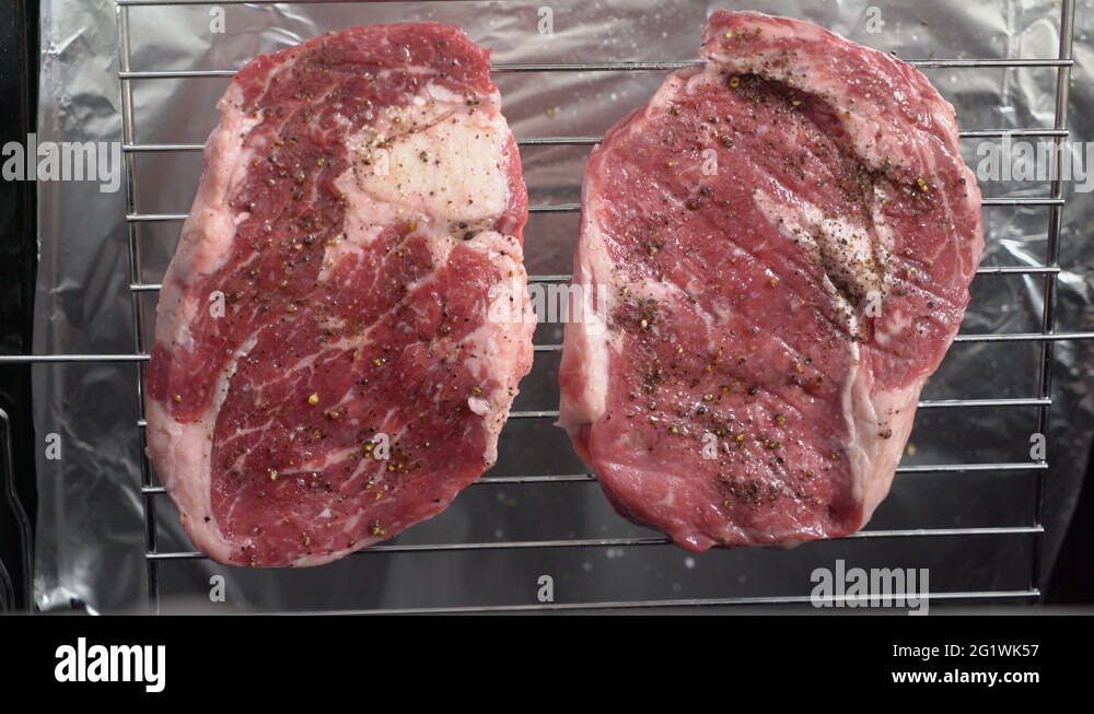 Cooking grilled steak ribeye in the oven with broiler top view Stock