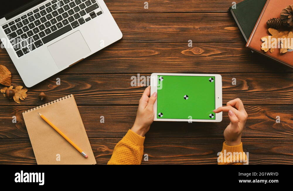 Woman tapping on the white tablet device with green screen. Horizontal
