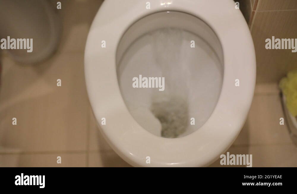 A piece of paper flushing down a water closet toilet bowl. Closeup