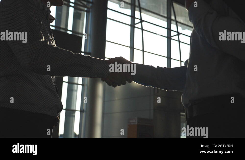 Friendly handshake of two businessmen greeting each other in the office ...