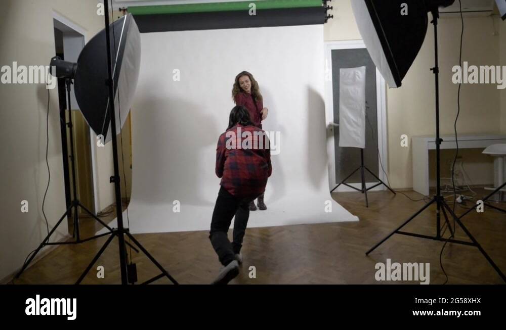 Beautiful young model and photographer couple flirting at work during a